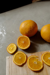 Wall Mural - Whole and cut oranges on a gray background
