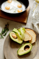 Wall Mural - Healthy breakfast: scrambled eggs, toast, avocado, lettuce, rosemary
