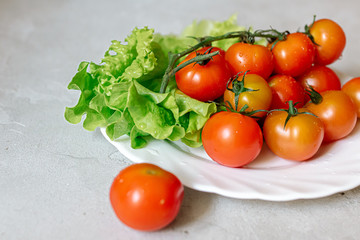 Wall Mural - Cherry tomatoes with lettuce on a gray background
