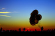Luftballons und Menschen im Sonnenuntergang