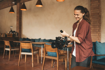 Professional woman videographer with gimball video slr