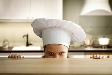 Wall Mural - Kid in kitchen and cook hat 