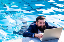 Business Man In Suit With Laptop On Swimming Pool. Funny Businessman Relaxing With Laptop.