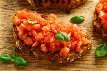 Wall Mural - Tomato bruschetta seasoned with basil on a rustic wooden board