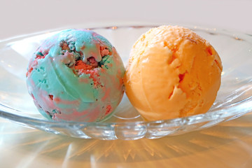 Wall Mural - Two Scoops of Bubble Gum Ice cream and Orange Ice Cream in a Glass Bowl	