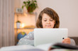 © SNAB - A smiling girl at digital tablet ,laptop sits at an online training session, a happy schoolgirl is delighted with distance online training.Online concept of school education and social distance during