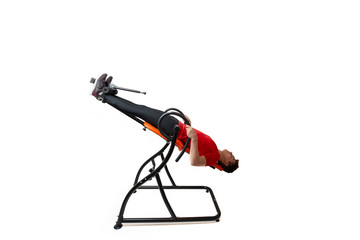 Man doing exercise on inversion table for his back pain, isolated on white