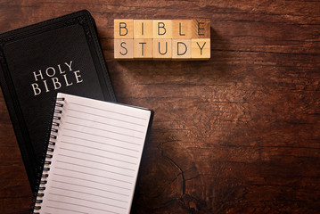 Bible Study in Block Letters on a Wooden Table with a Holy Bible