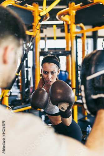 фотографія Young attractive woman with instructor on kickboxing training
