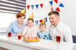 © alenaphoto - Happy family, mother, father, son, daughter celebrating a children's birthday party with the cake. Emotions, joy