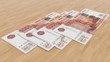 © Ivan - Four five-thousandths banknotes of rubles with a depth of field on a wooden background. 3d illustration.