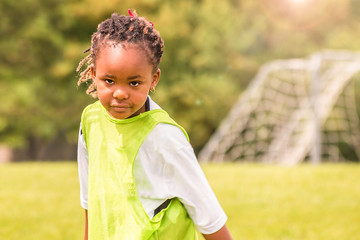 Wall Mural - A close portrait of a young African girl with a background of nature	