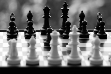 black and white chessmen on a chessboard during a chess game