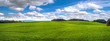 panoramic view fields winter wheat at hilly terrain in spring with cloudy sky
