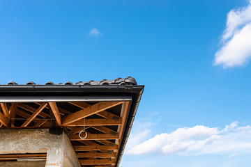 the roof of a single-family house covered with a new ceramic tile in anthracite against the blue sky