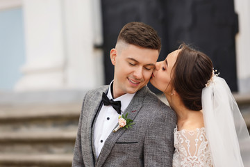 Happy newlyweds kisses at wedding day. Portrait of beautiful bride and elegant groom