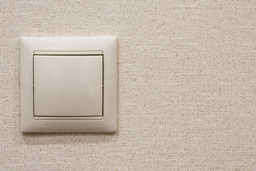 Single switch on beige wallpaper, copy space