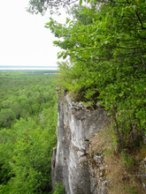 Tree Covered Rock Cliff Overlooking A Forest And Lake Below On Manatoulin Island, Ontario, Canada