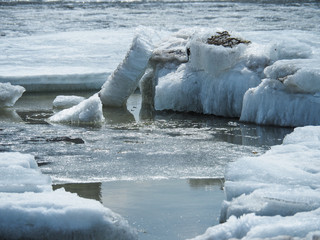 Large, dirty pieces of ice melt in the water and crawl onto each other.