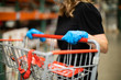 © Ursula Page - A woman shopping for groceries and necessities for her family inside a warehouse-style store during the pandemic Covid-19 coronavirus pandemic and she is wearing a face mask and latex rubber gloves
