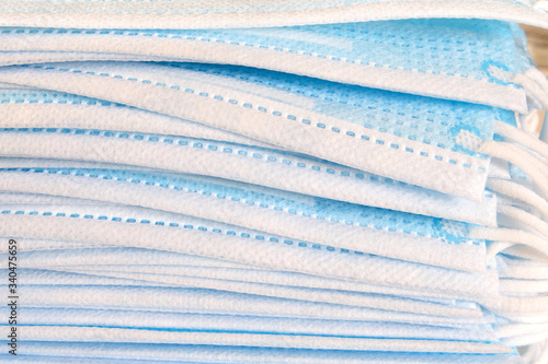 Fotomural Pieces of 3 ply medical grade face mask stacked, closeup view