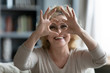 © fizkes - Elderly woman sit in living room connected fingers showing heart symbol close up, old people cardiovascular disease prevention treatment, health check-up, cardio vitamins, sign of kindness and charity