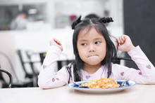 Asian Child Cute Or Kid Girl Anorexia Or Sad And Bored Food Or Untasty Boredom With Frown On Wood Table For Breakfast Or Lunch Eating At Restaurant Or Food Court And Canteen On Preschool Or Nursery