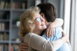 © fizkes - Loving elderly mother in glasses closed eyes enjoy moment strong cuddles adult son after long separation, grandmother glad to see grandson multi generational family reunion, love and bonding concept