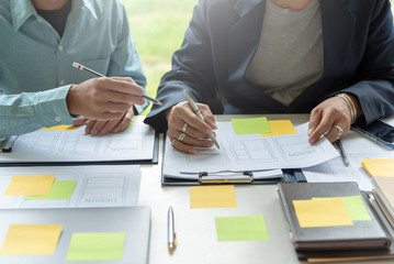 mobile application designers and website designers brainstorm and planning project work together.