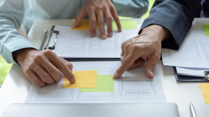 Mobile application designers and website designers brainstorm and planning project work together.