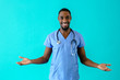 Portrait of a friendly male doctor or nurse wearing blue scrubs uniform and stethoscope, with arms out making positive gesture