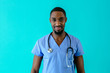 © Carlos David - Portrait of a friendly male doctor or nurse wearing blue scrubs uniform and stethoscope, isolated on blue studio background