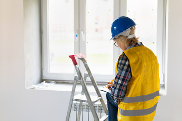 A female builder worker inspects a construction site.