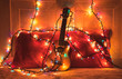 © valebenifer - Ukulele leaning on a red pillow on a bed and wrapped over colored lights