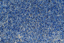 A Lot Of Small Blue Glass Stones On The Wall Surface Are Glued With An Adhesive Compound. Pieces Of Glass Of Different Shapes. Decoration Of The Building Wall Outside. Background, Texture.