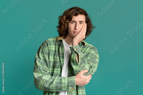 Photographie Attractive millennial guy feeling bored or tired on color background