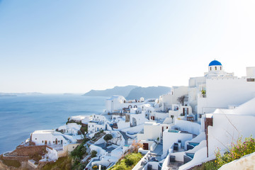 Famous blue dome churches in Oia, (Santorini, Greece) in the morning. White architecture of Oia village on Santorini island, Greece. Traditional tourism in mediterranean white architecture view