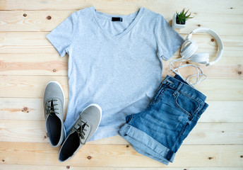 Wall Mural - Gray female t shirt mock up flat lay on wooden background. Top front view