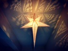 Close-up Of Illuminated Star Shape Christmas Light Hanging Form Ceiling