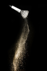 Wall Mural - golden powder splash and brush for makeup artist or graphic design in black background