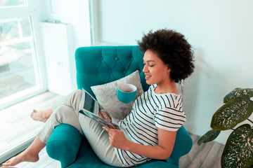 Sticker - Woman reading a magazine and drinking tea