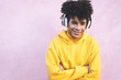 © Alessandro Biascioli - Happy Afro man listening music with wireless headphones outdoor - Young African guy portrait - Youth millennial generation lifestyle and people technology concept - Violet background