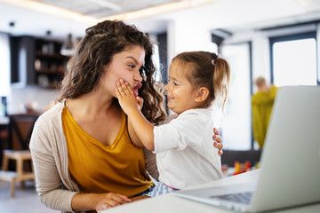 Wall Mural - Mother at home trying to work with child distracting her