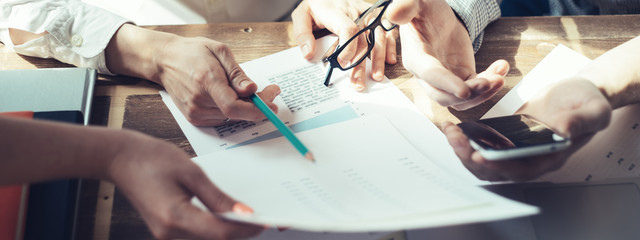 Fototapete - Business people working together. Loft office and smart casual dress code. Researching new product strategy. Electronic devices and paperwork on the table. Wide screen panoramic