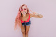 © Look! - Charming girl with long pink hair posing on white background with peace sign. Indoor shot of pretty caucasian lady with tanned body expressing positive emotions.
