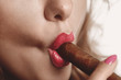 young girl with big brown cigar in her lips