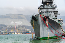 Novorossiysk, Russia - March 25, 2020. - Cruiser Mikhail Kutuzov Is Museum Ship. Close-up. Warship On Pier Against Blurred Background Of Novorossiysk Commercial Sea Port. Novorossiysk Is Hero City.