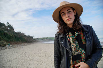 caucasian woman with hat and vintage shirt in a beach