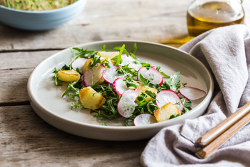 Wall Mural - fresh salad with arugula, radish, baked potatoes and aromatic herbs with olive oil