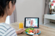 © ake1150 - Asian young woman virtual happy hour meeting and eating food online together with her mother in video conference with digital tablet for a online meeting in video call for social distancing.